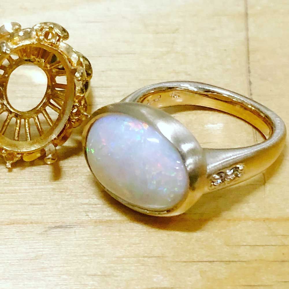 Custom design opal gold ring laying on wooden table